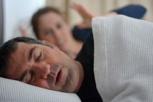 Man sleeping in be but suffering from sleep apnea