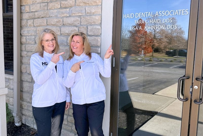 Young man in black shirt shaking hands with dentist