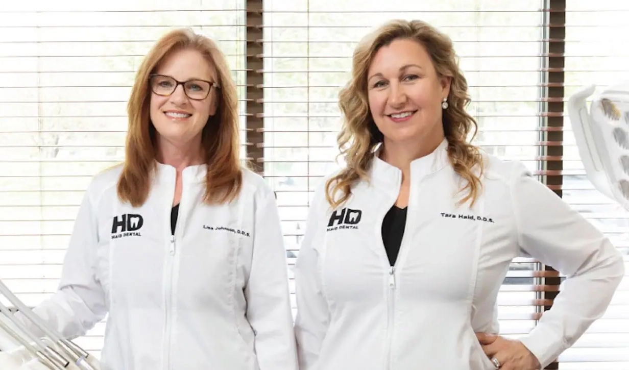 Young man in black shirt shaking hands with dentist